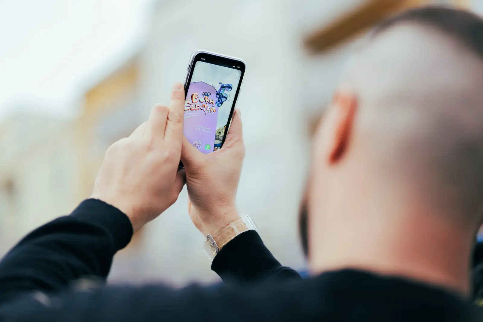 A passer-by viewing the animated mural through the lens on a phone